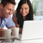 Happy couple looking at laptop computer