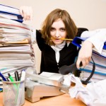 Tired businesswoman with telephones