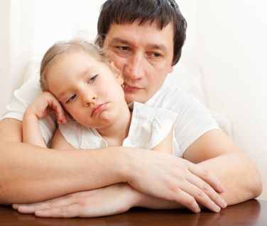 Father comforts a sad girl